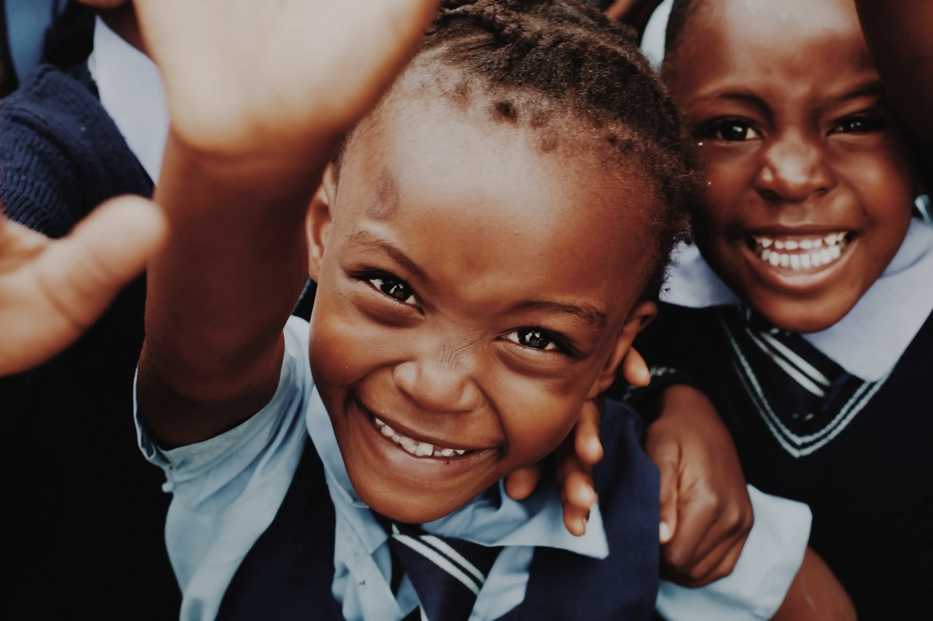 Child smiling and reach upwards.