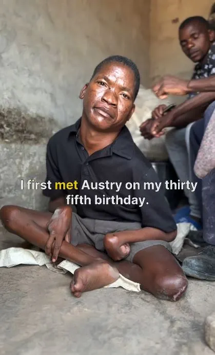 Image of Austry, a disabled man from Zambia, as he poses for the camera amongst his home.